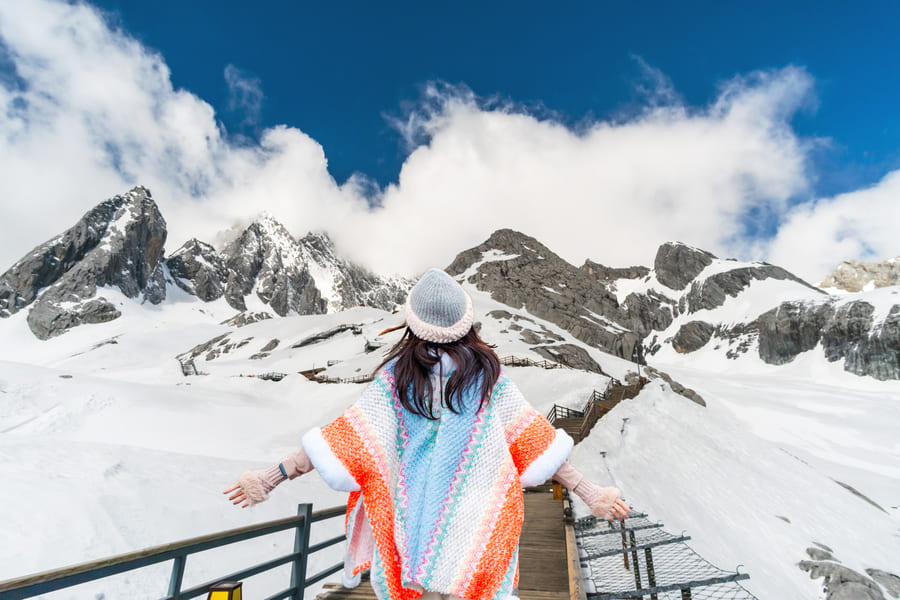 Mujer caminando en la nieve en Yulongshang